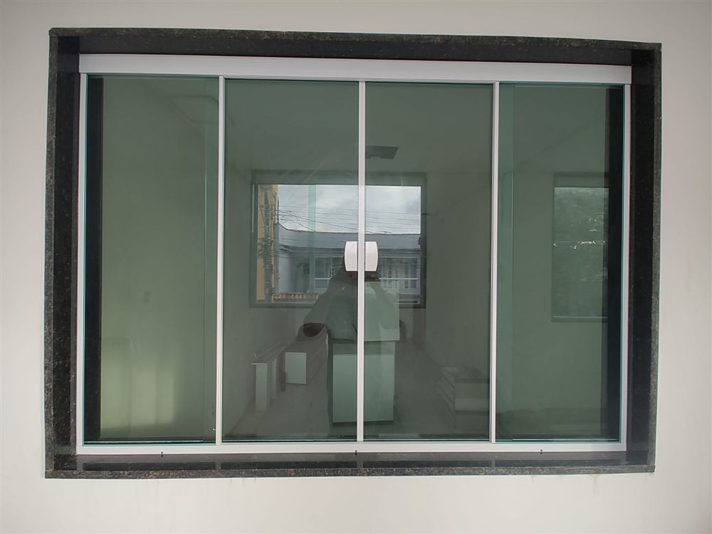 Porta de vidro de correr em esquadria de alumínio, vista para prédios vizinhos