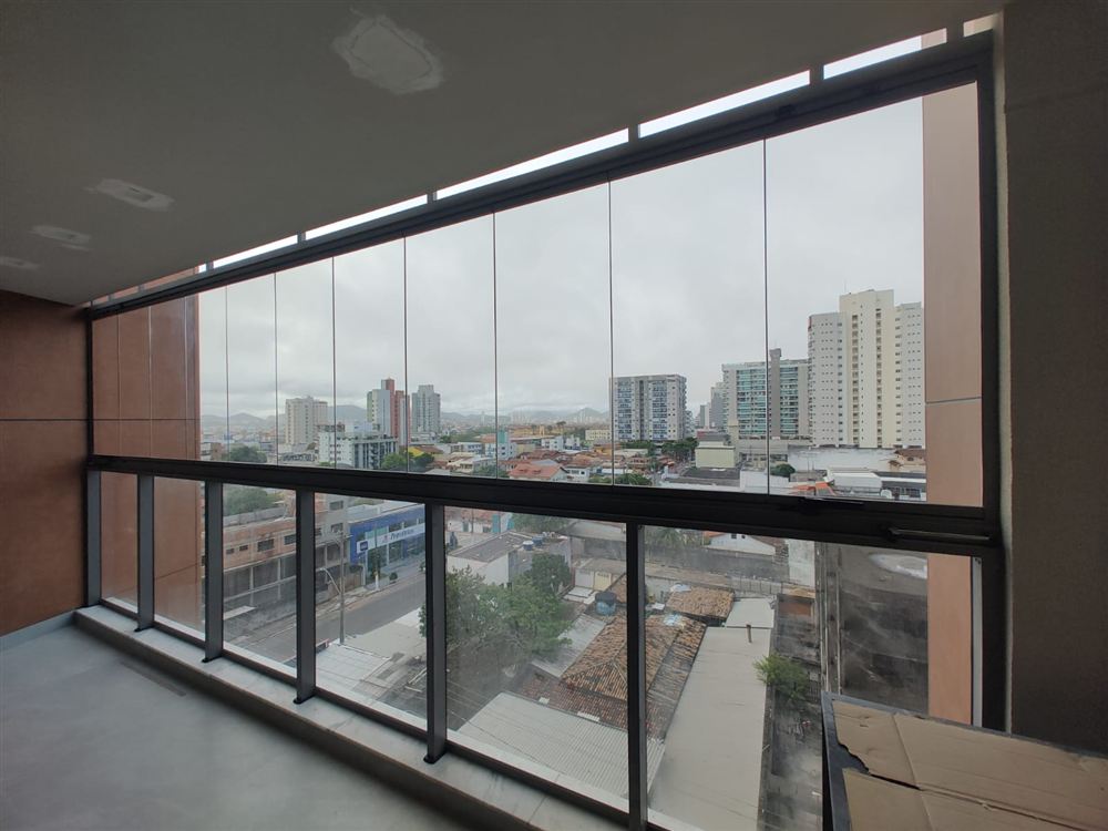 Varanda com fechamento de vidro integrada ao ambiente, vista para a cidade