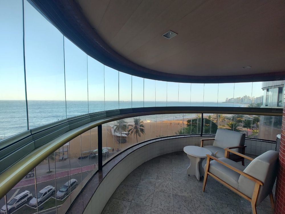 Fechamento de varanda em vidro curvo, com vista para a praia